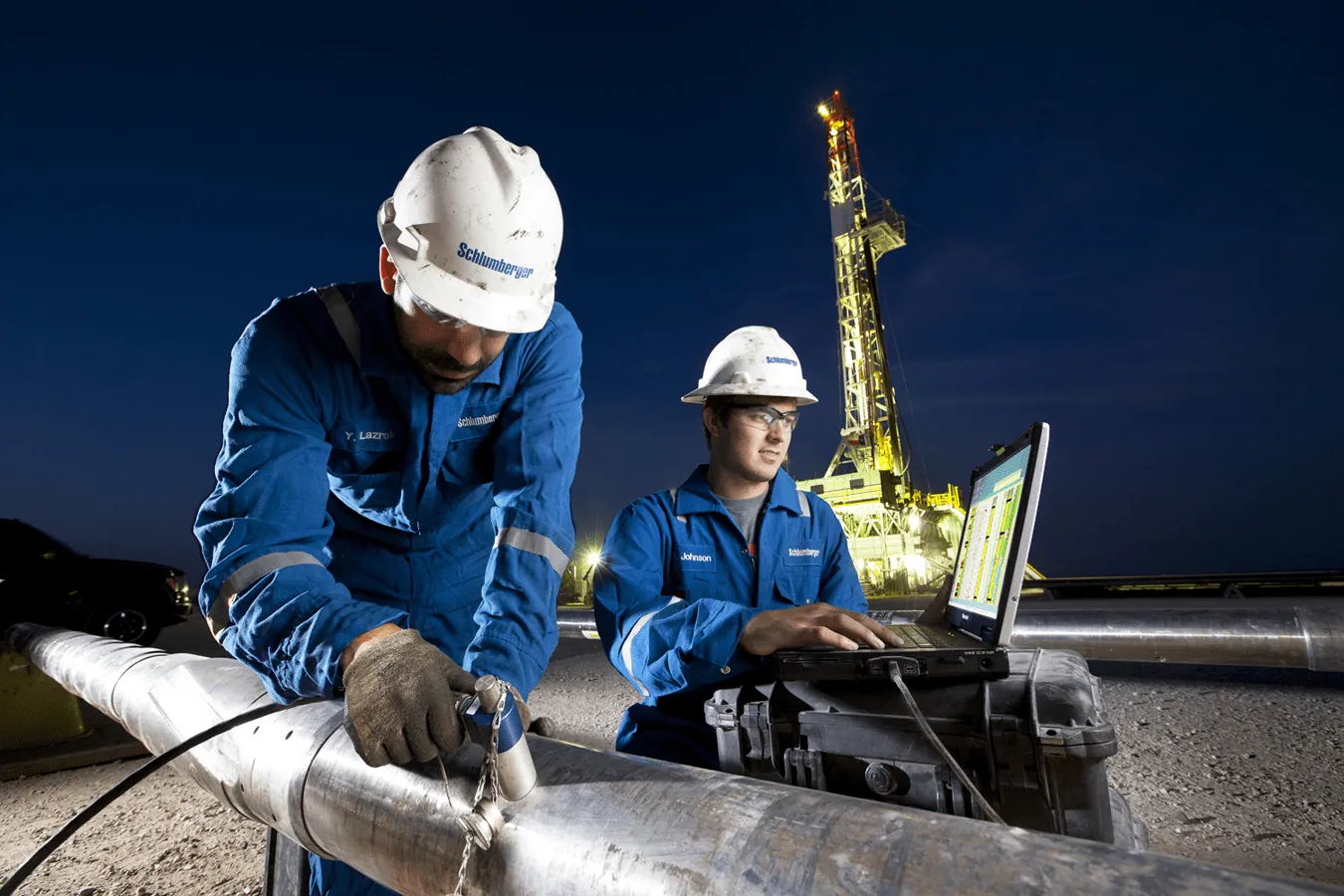 Technicians testing pipework with a handheld instrument
