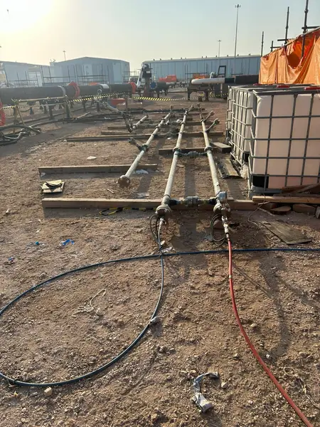 Pipe spools laid out on the ground with hoses connected