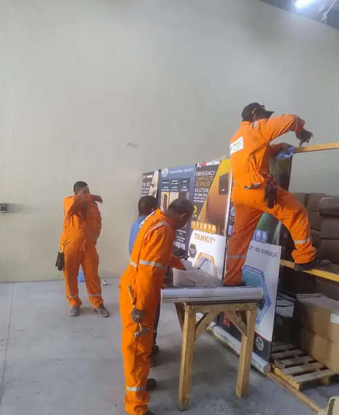 Technicians handling boxed equipment in a workshop bay