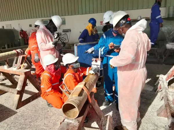 Crew working on a pipe section on trestles in the workshop