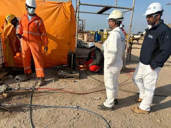 Crew at a work area enclosed with orange sheeting on site